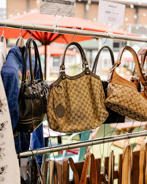 Handbags hanging on a rack with visible brand logos