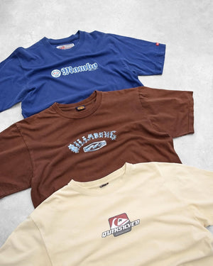 Three t-shirts with different vintage Surfwear logos on a light gray background